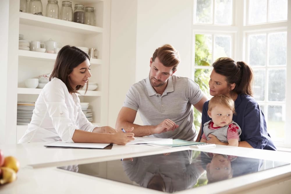 financial advisor giving guidance to young couple with their infant